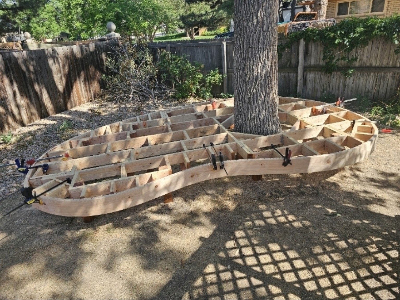 Custom deck framing in progress around a mature tree